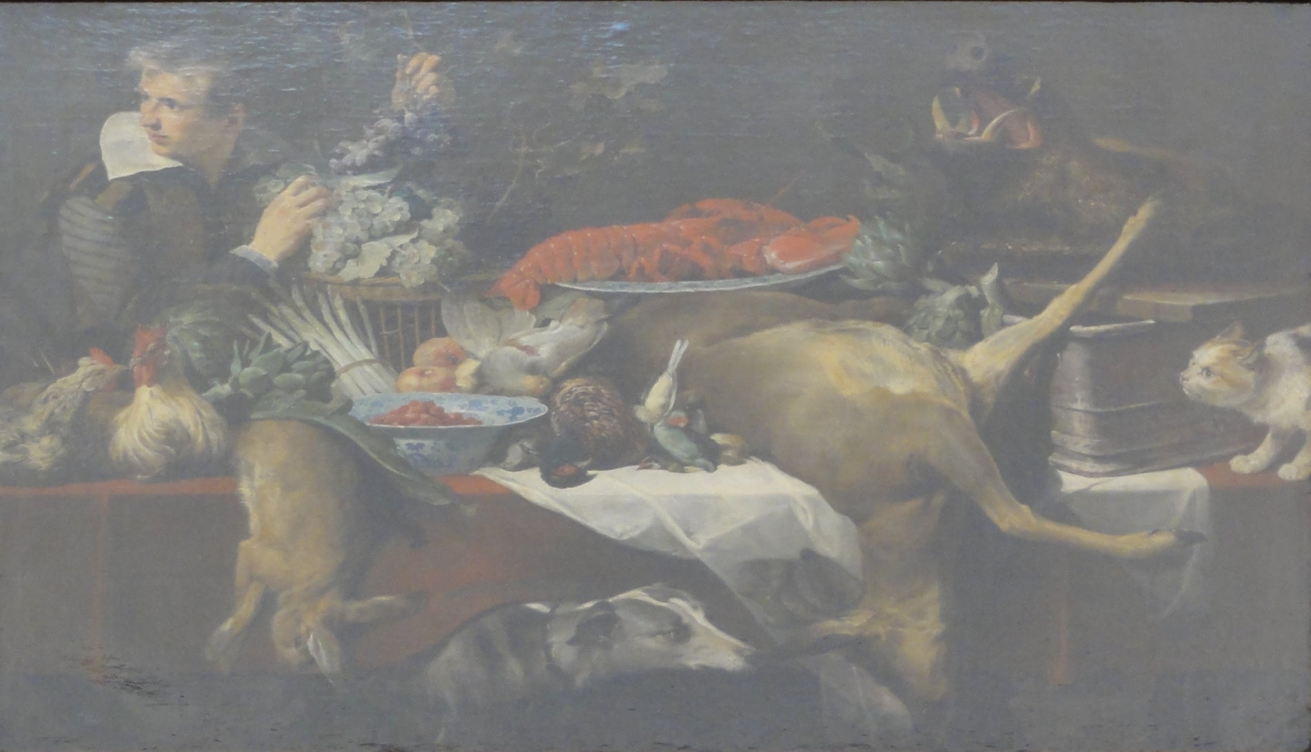 Scène de cuisine avec du gibier et des légumes, un garçon de cuisine tenant une grappe de raisin. - Frans Snyders